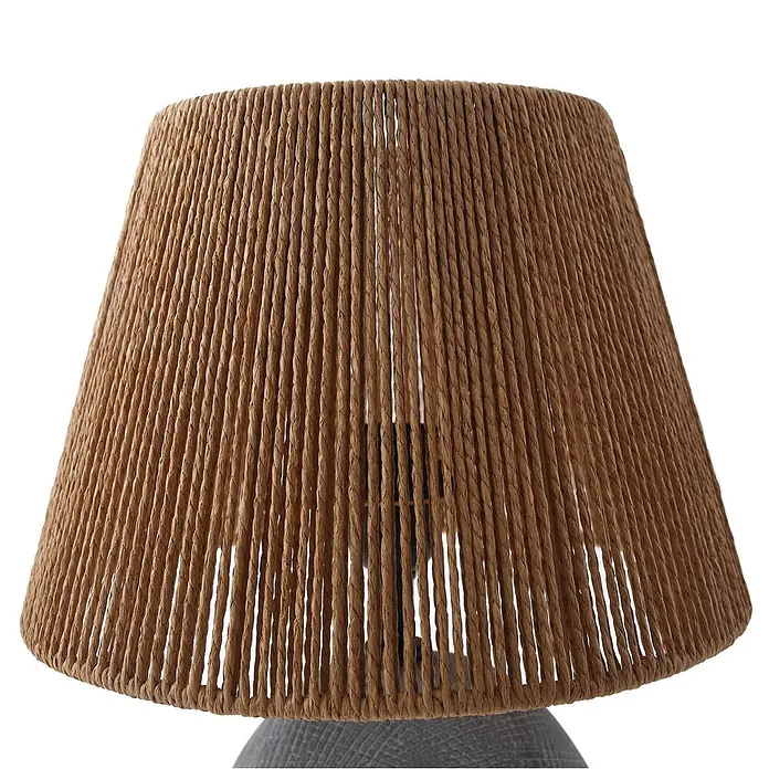 Lindby Tischleuchte Seasur - L x B x H: 29 x 29 x 48 cm, alu / grau / zink, braun / rost, E27 - Brauner Lampenschirm aus Naturfasern mit vertikaler Webstruktur, der Teile des Lampenfußes zeigt.
