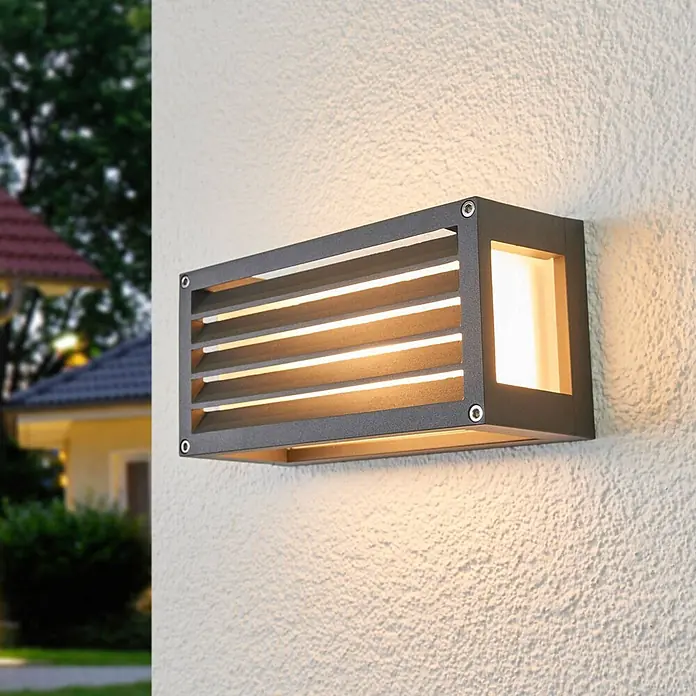 Lucande Außenwandleuchte Aurelien - schwarz, IP54 - Rechteckige anthrazitfarbene Metall-Außenwandleuchte mit Lamellendesign, beleuchtet strukturierte Wand mit warmem Licht.