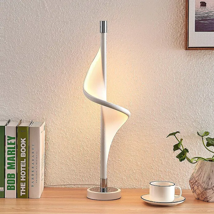 Lucande Tischleuchte Edano - L x B x H: 16 x 16 x 60 cm, weiß / opal - Weiße spiralförmige LED-Tischlampe auf einem Holzschreibtisch mit Büchern und Deko. Modernes Design spendet warmes Licht.