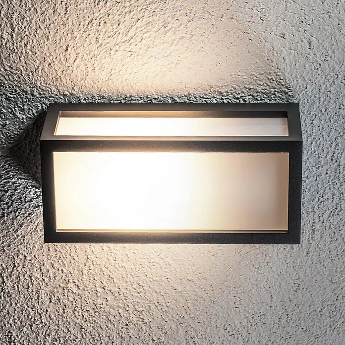Lucande Außenwandleuchte Tame - schwarz, IP54 - Dunkle, rechteckige LED-Wandleuchte an einer strukturierten Wand, die Licht nach oben und unten abgibt.