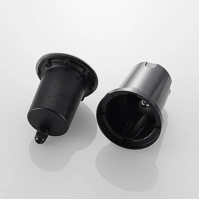 Lucande LED-Gartenstrahler Doris - 3.000 K, 12 x 12 x 15 cm - Zwei schwarze zylindrische Gehäuse, eines strukturiert mit Stecker, das andere glatt und hohl.