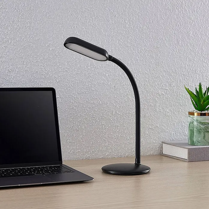 Prios Tischleuchte Opira - schwarz, schwarz - Schwarze flexible Schreibtischlampe mit ovalem Leuchtkopf, spendet Licht auf einem Arbeitsplatz.
