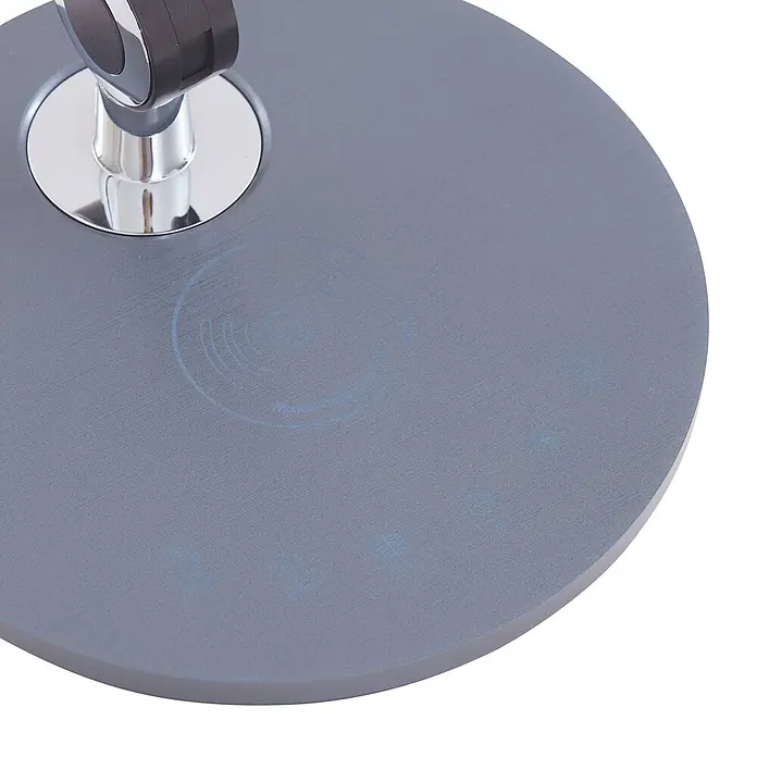 Lindby Tischleuchte Nyxaris - alu / grau / zink, alu / grau / zink - Runde, graue Lampenbasis aus gebürstetem Metall mit Chrom-Armanschluss, blauen Wireless-Charging- und Touch-Symbolen.