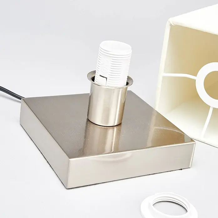 Lindby Tischleuchte Martje - L x B x H: 12 x 12 x 34,5 cm, creme / amber, E14 - Quadratischer Lampenfuß aus gebürstetem Metall mit weißer Lampenfassung, teilweise sichtbarem cremefarbenem Lampenschirmrahmen und weißem Befestigungsring.