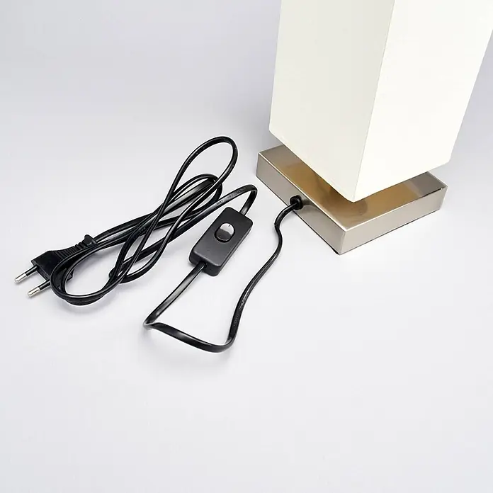 Lindby Tischleuchte Martje - L x B x H: 12 x 12 x 34,5 cm, creme / amber, E14 - Lampenfuß aus gebürstetem Metall mit cremfarbenem Stoffschirm, verbunden mit einem schwarzen Stromkabel, das einen Schnurschalter und einen europäischen Stecker hat.
