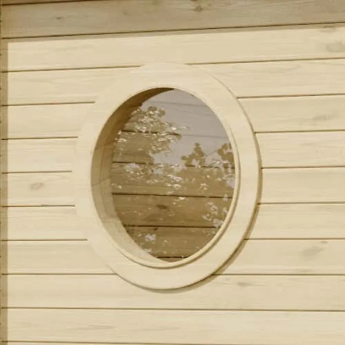Alpholz Gartenhaus Maria Rondo 44 B - Außenmaß inkl. Dachüberstand (B x T): 400 x 320 cm, Holz, Naturbelassen - Rundes Fenster mit hellem Holzrahmen in einer hellen Holzplankenwand, das Bäume widerspiegelt.