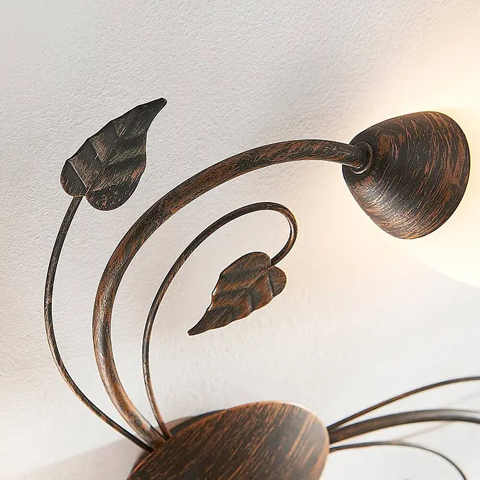 Lindby Deckenleuchte Stefania - L x B x H: 46 x 46 x 9,5 cm, braun / rost, E14 - Nahaufnahme einer rustikalen, dunkelbronzenen Wand- oder Deckenleuchte mit dekorativen Metallblättern und einem mattierten Glasschirm.
