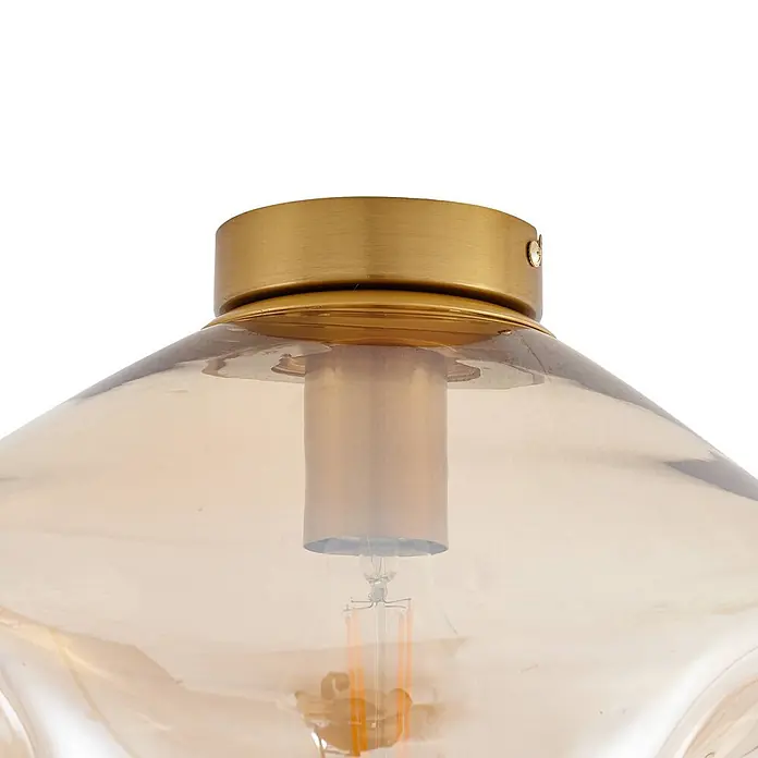 Lindby Deckenleuchte Lelia - L x B x H: 35 x 35 x 25 cm, creme / amber, E27 - Nahaufnahme einer Deckenleuchte mit gebürsteter Messingbasis und bernsteinfarbenem Glasdom mit Glühbirne.