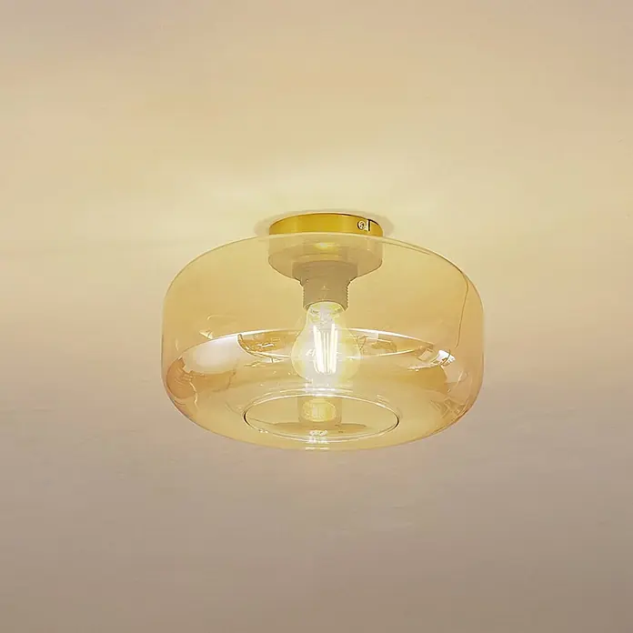 Lindby Deckenleuchte Hildur - creme / amber, E27 - Deckenleuchte mit goldenem Messingsockel und bernsteinfarbenem Glasschirm, der eine Glühbirne umschließt.