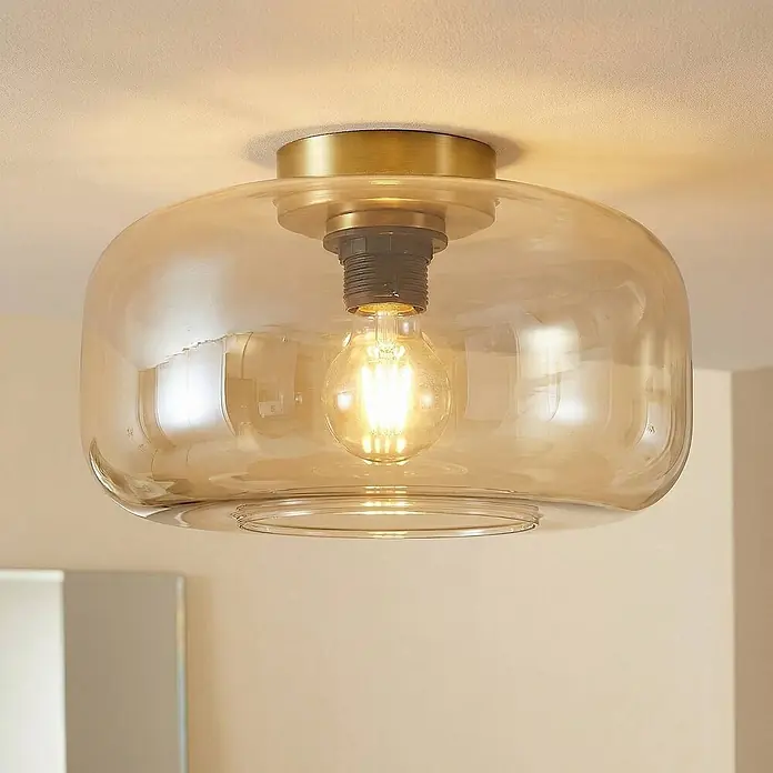 Lindby Deckenleuchte Hildur - creme / amber, E27 - Messingfarbene Deckenleuchte mit runder, bernsteinfarbener Glasschirm und sichtbarer LED-Glühbirne.