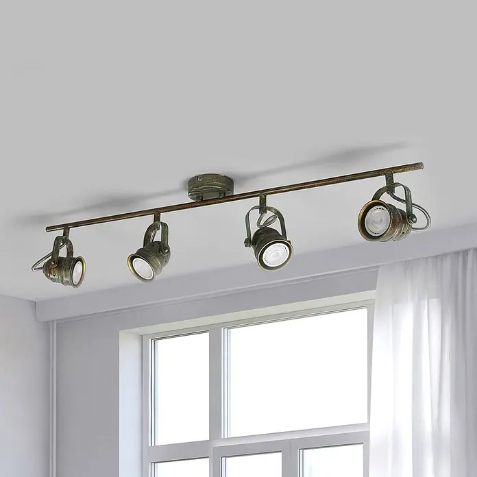 Lindby Deckenleuchte Leonor - bronze / altmessing, bronze / altmessing, GU10 - Deckenstrahlerleiste aus antikem Bronze mit vier verstellbaren Strahlern, über einem Fenster montiert.