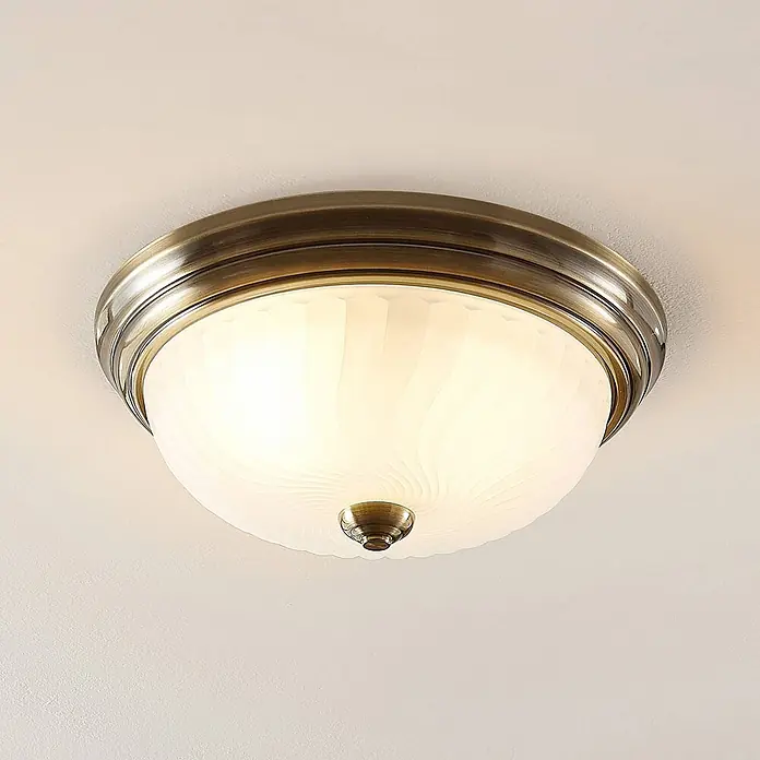 Lindby Deckenleuchte Pakka - bronze / altmessing, E27 - Runde Deckenleuchte mit antikem Messingfuß und kuppelförmigem, satiniertem Glasdiffusor mit dezentem Wirbelmuster.