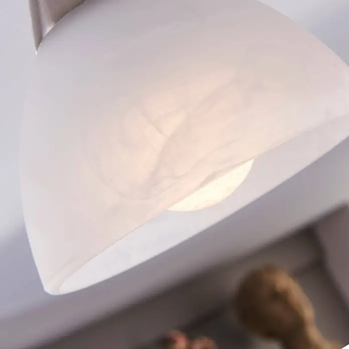 Lindby Deckenleuchte Della - alu / grau / zink, E14 - Nahaufnahme einer leuchtenden Pendelleuchte mit transluzentem weißem Schirm, die eine warme LED-Birne im Inneren zeigt.