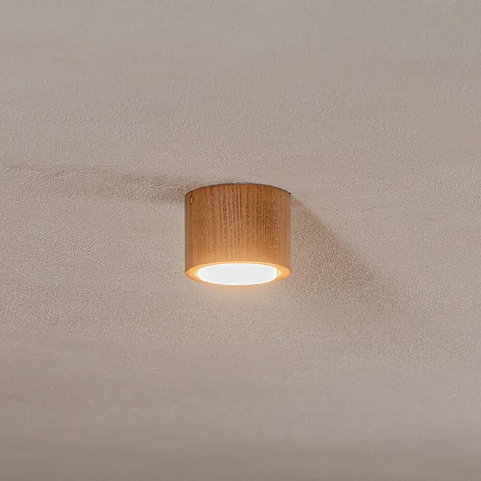 Envostar Deckenleuchte Ernest - Holz hell, 2GX53 - Eine runde, hellbraune Deckenleuchte aus Holz, die an einer strukturierten Decke montiert ist und warmes Licht abgibt.