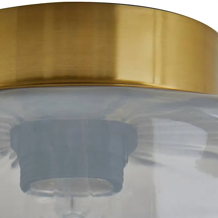 Lindby Deckenleuchte Hildur - L x B x H: 22 x 22 x 15,3 cm, alu / grau / zink, E27 - Nahaufnahme einer Deckenleuchte mit goldenem Metalloberteil und klarem Glasschirm, der eine schwarze Lampenfassung zeigt.