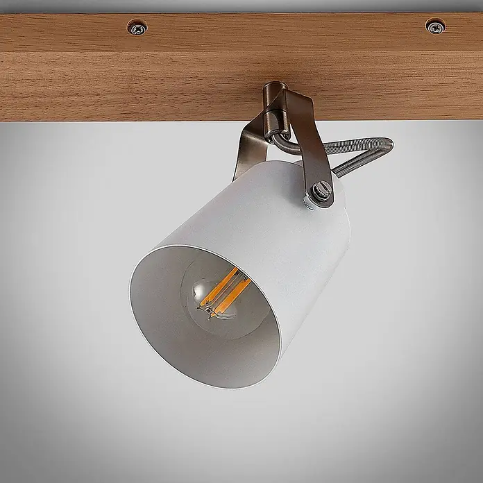 Lindby Deckenleuchte Blana - Holz hell, E14 - Weißer zylindrischer Strahler mit LED-Glühfadenlampe, an Holzbalken montiert mit bronzefarbener Halterung.