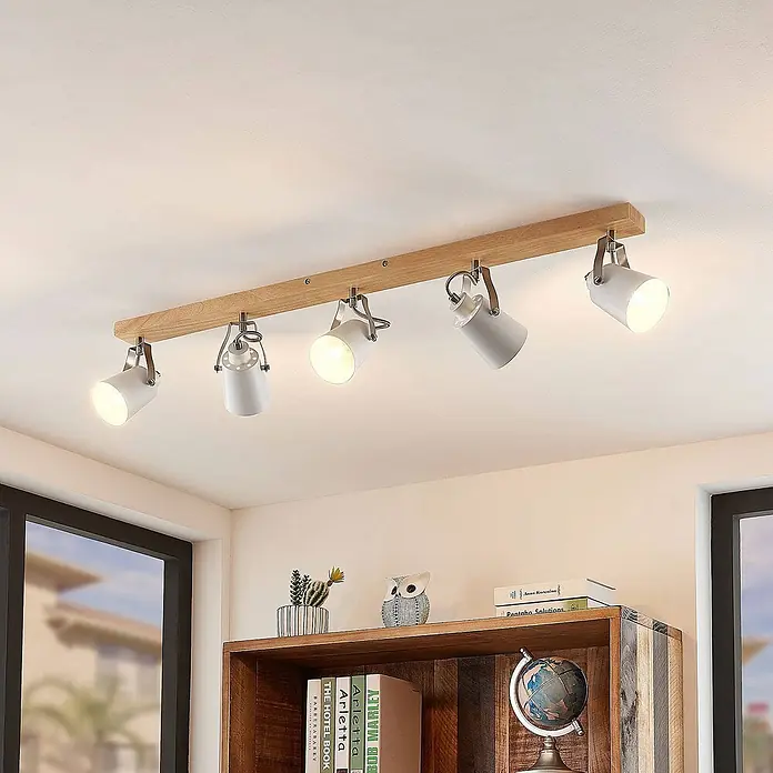 Lindby Deckenleuchte Blana - Holz hell, E14 - Moderne Deckenleuchte mit fünf verstellbaren weißen Strahlern an einem Holzsteg, die den Raum beleuchten.