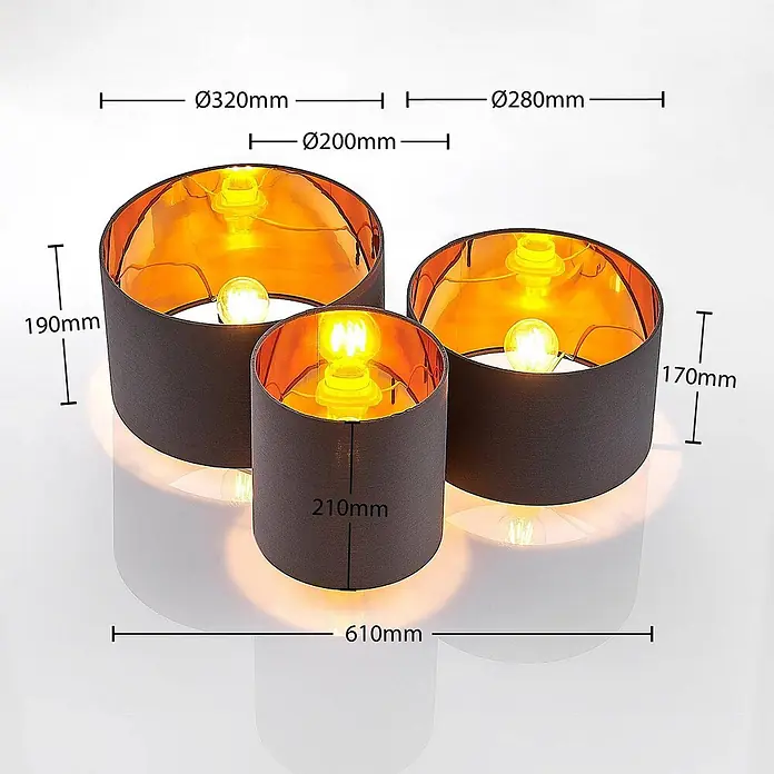 Lindby Deckenleuchte Laurenz - alu / grau / zink, E27 - Set aus drei zylindrischen Lampenschirmen aus dunklem Stoff mit glänzender goldener Innenseite und Glühbirnen. Produktabmessungen sind deutlich angegeben.