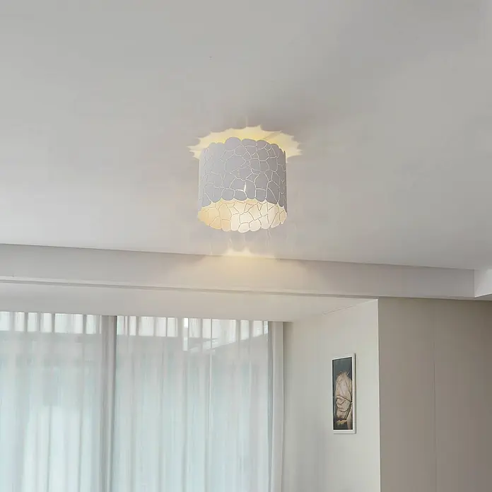 Lindby Deckenleuchte Aralena - weiß / opal, E27 - Weiße Deckenleuchte mit strukturierter, mosaikähnlicher Schirm, die einen Raum mit warmem Licht und dekorativen Mustern an der Decke beleuchtet.