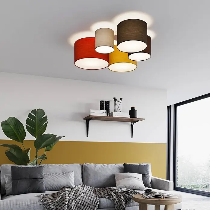 Lindby Deckenleuchte Laurenz - L x B x H: 93 x 93 x 25,5 cm, Multicolour, E27 - Fünf zylindrische Deckenleuchtenschirme in Rot, Beige, Gelb und zwei Brauntönen, die ein modernes Wohnzimmer beleuchten.