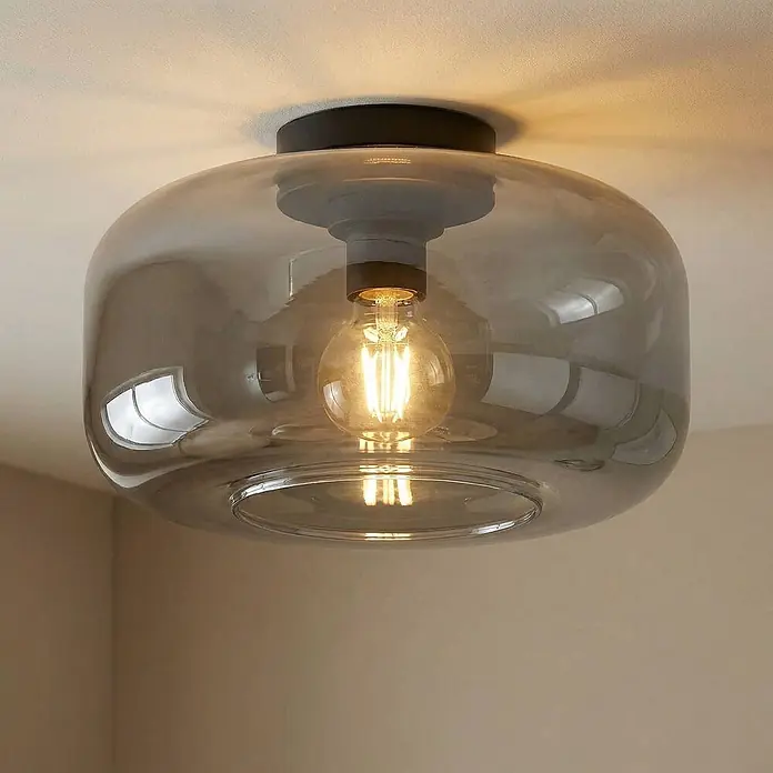 Lindby Deckenleuchte Hildur - alu / grau / zink, E27 - Moderne Deckenleuchte mit rauchgrauem Glasschirm und sichtbarer warmer Glühbirne, an der Decke montiert.