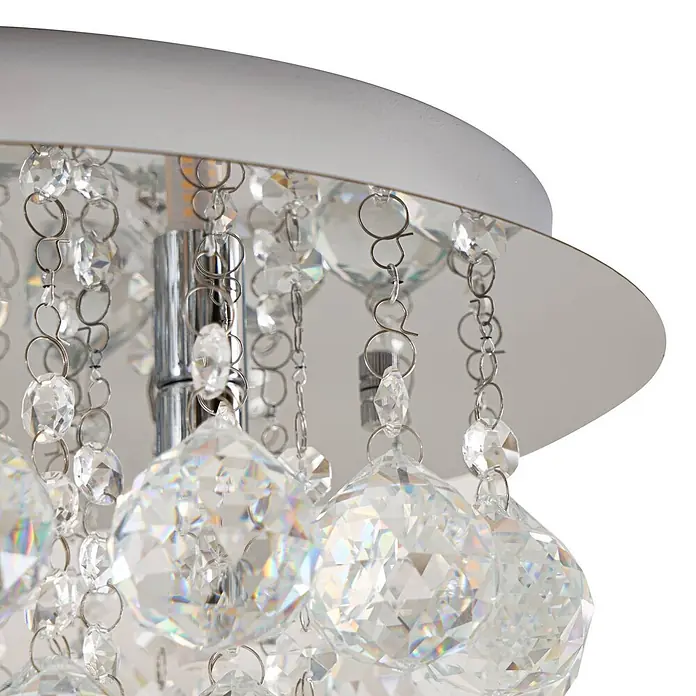 Lindby Deckenleuchte Antonino - chrom / silber, klar / transparent, G9 - Nahaufnahme einer modernen Deckenleuchte mit silberner Basis und funkelnden klaren facettierten Kristallen an Metallketten.