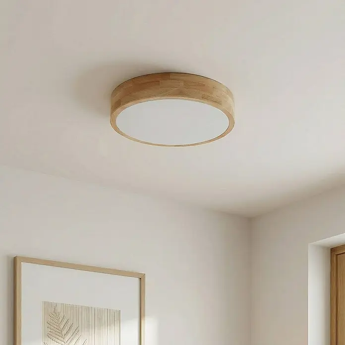 Lindby Deckenleuchte Tanju - Holz hell, E27 - Runde Holzdeckenleuchte mit weißem Diffusor, bündig an einer hellen Decke montiert.