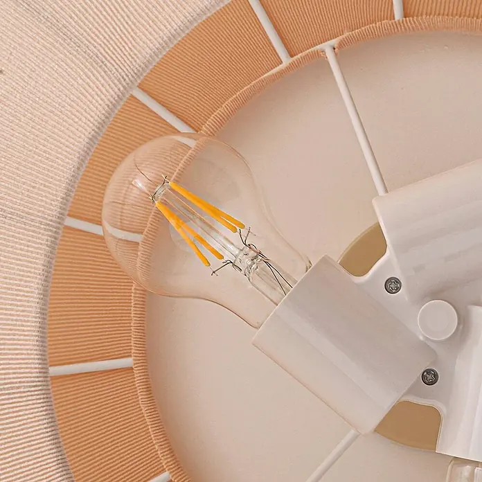 Lindby Deckenleuchte Helin - creme / amber, E27 - Eine klare LED-Birne mit orangefarbenen Filamenten in einer weißen Fassung, umgeben von einem Pfirsich- und weiß gestreiften Stoffschirm.