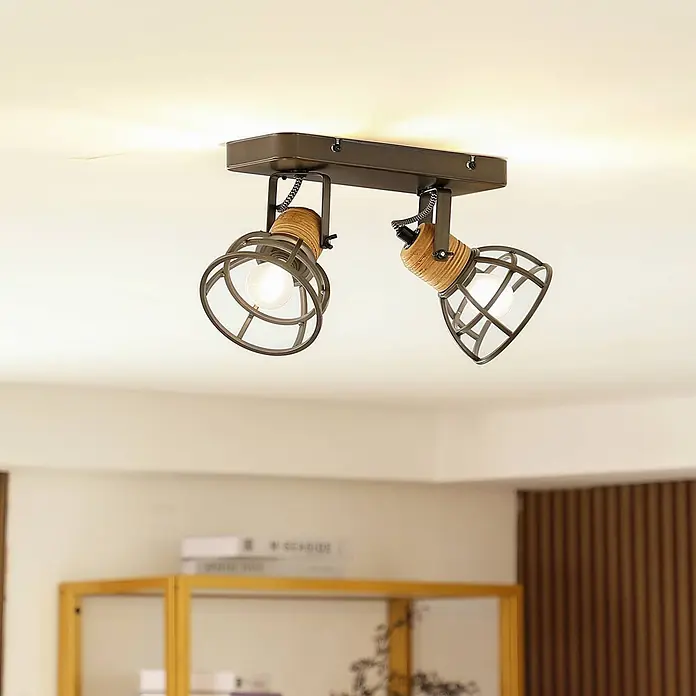 Lindby Deckenstrahler Arinthea - schwarz, schwarz, E14 - Zwei Deckenstrahler im Industriestil mit dunklen Metallkäfigen, Holzakzenten und leuchtenden Glühbirnen.