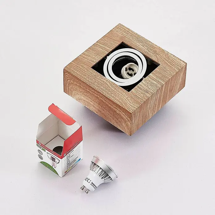 Arcchio Deckenstrahler Vince - Holz hell, Holz hell, GU10 - Ein quadratisches Einbauleuchtengehäuse in Holzoptik, eine offene Schachtel und eine GU10 LED-Lampe.