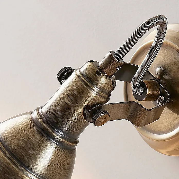 Lindby Deckenstrahler Perseas - bronze / altmessing, bronze / altmessing, GU10 - Nahaufnahme eines verstellbaren Wandstrahlers in Antikmessing-Optik, mit flexiblem Spiralkabelmantel und verstellbaren Gelenken.