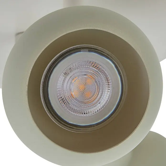 Lindby Deckenstrahler Huby - creme / amber, grün, GU10 - Nahaufnahme eines hellgrünen Strahlers mit sichtbarer LED-Birne. Die Birne hat eine klare Abdeckung und strahlt warmes Licht aus.