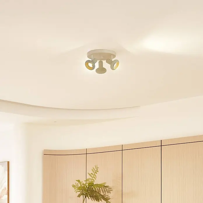 Lindby Deckenstrahler Huby - creme / amber, grün, GU10 - Weiße Deckenleuchte mit drei verstellbaren Strahlern, die warmes Licht abgeben, an einer hellen Decke montiert.