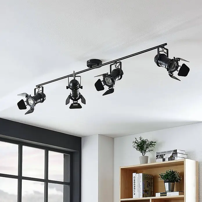 Lindby Deckenstrahler Tilen - schwarz, schwarz, GU10 - Schwarze Stromschiene mit vier verstellbaren Strahlern mit Blenden, an einer weißen Decke in einem modernen Raum montiert.