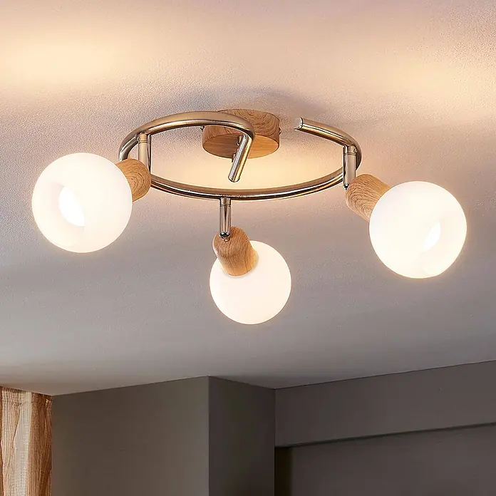 Lindby Deckenstrahler Svenka - Holz hell, E14 - Moderne Deckenleuchte mit verchromtem Rundrahmen, hellen Holzdetails und drei leuchtenden kugelförmigen weißen Glasschirmen.