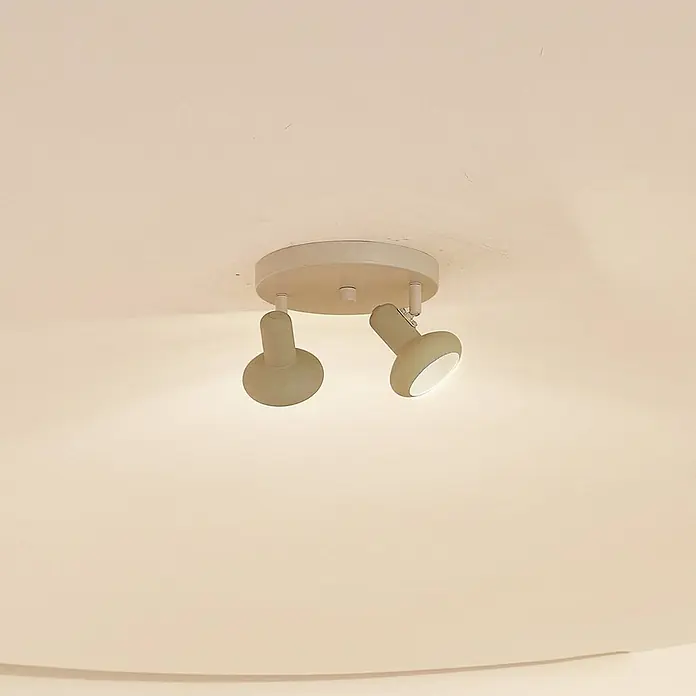 Lindby Deckenstrahler Huby - creme / amber, grün, GU10 - Hellbeige Deckenleuchte mit zwei Strahlern, eine Lampe leuchtet, an einer hellen Decke montiert.
