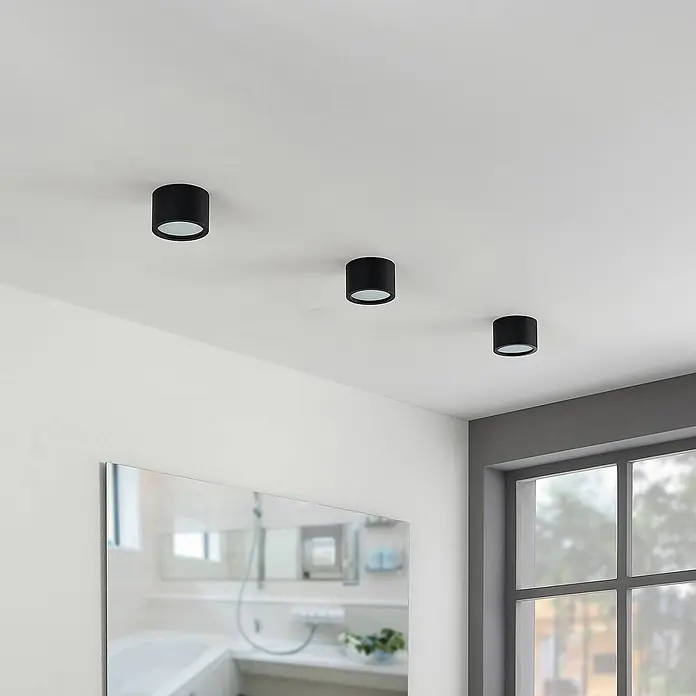 Arcchio Deckenstrahler Nieva - L x B x H: 10 x 10 x 6,5 cm, schwarz, schwarz, 2GX53 - Drei schwarze zylindrische LED-Deckenleuchten, beleuchten einen modernen Raum.