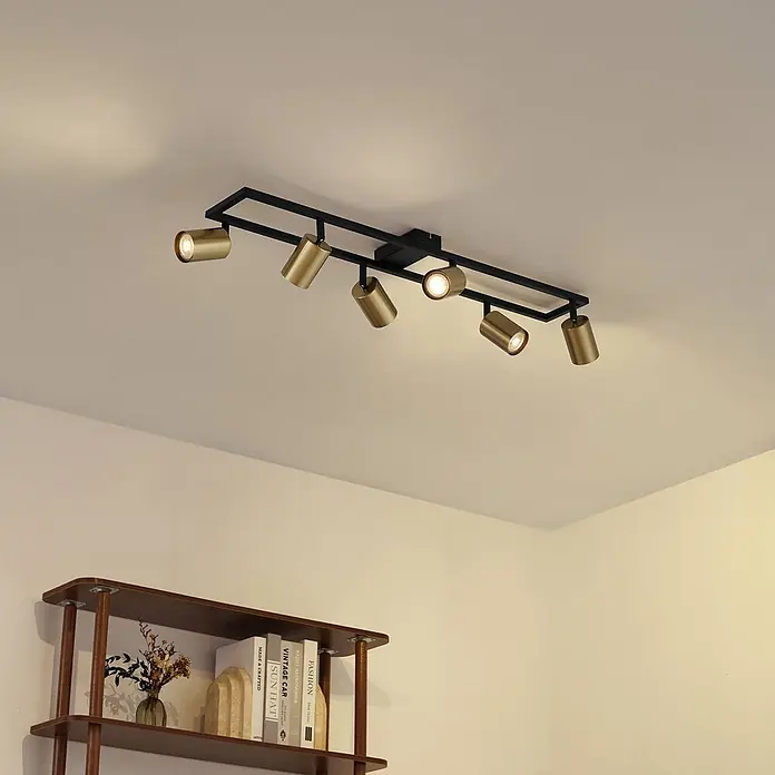 Lindby Deckenstrahler Bravius - schwarz, messing / gold, GU10 - Schwarze rechteckige Deckenleuchte mit sechs messingfarbenen Strahlern, die einen Raum beleuchten.