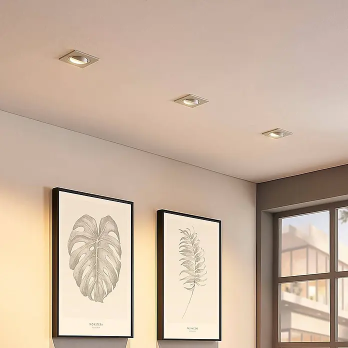 Arcchio Deckenstrahler Sophia - weiß / opal, GU10 - Quadratische silberne Einbaustrahler spenden warmes Licht in einem modernen Raum mit Pflanzenbildern.