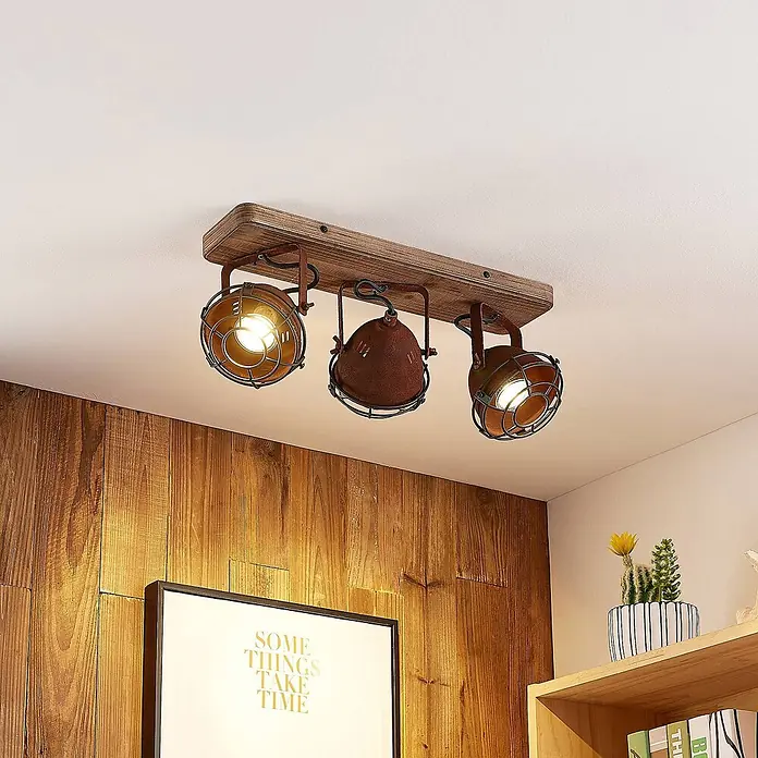 Lindby Deckenstrahler Farovi - Holz dunkel, braun / rost, GU10 - Industrielle Deckenleuchte mit drei verstellbaren Strahlern auf einem Holzträger, mit rostfarbenen Metallkäfigen.