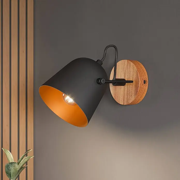 Lindby Deckenstrahler Adalin - L x B x H: 12 x 12 x 15,7 cm, Holz dunkel, schwarz, E14 - Schwarze konische Wandleuchte mit Kupfer-Innenseite, leuchtender Glühbirne und runder Holzhalterung.
