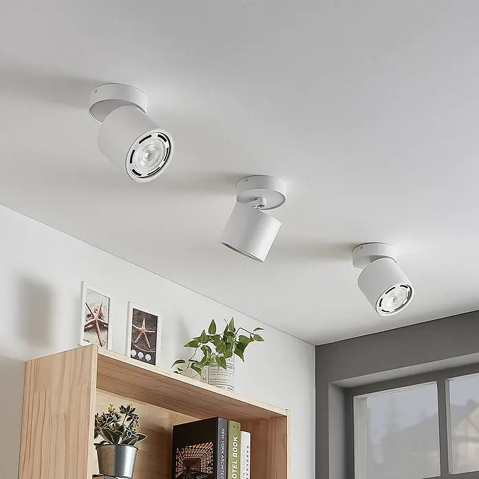 Arcchio Deckenstrahler Mabel - weiß / opal, weiß / opal, GU10 - Drei weiße, verstellbare Deckenstrahler in einem modernen Wohnraum mit Regalen und Fenster.