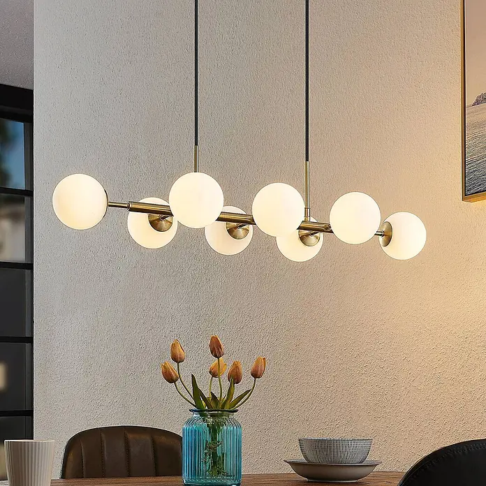 Lindby Pendelleuchte Kiamo - L x B x H: 82,5 x 32,5 x 10 cm, weiß / opal, messing matt, opalweiß, G9 - Messingfarbene Pendelleuchte mit mehreren kugelförmigen Milchglasschirmen über einem Esstisch.