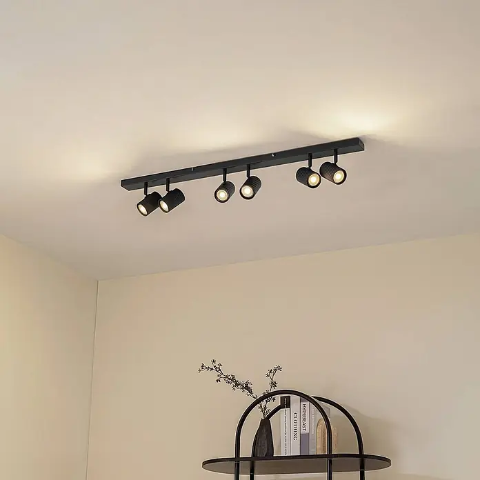 Lindby Deckenstrahler Kardis - L x B x H: 100 x 6 x 16 cm, alu / grau / zink, alu / grau / zink, GU10 - Schwarze lineare Deckenleuchte mit sechs verstellbaren Strahlern beleuchtet einen Raum.