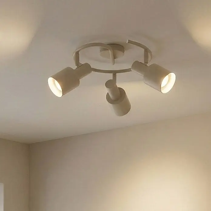 Lindby Deckenstrahler Ovelia - creme / amber, creme / amber, E27 - Beigefarbene Deckenleuchte aus Metall mit vier verstellbaren Strahlern, drei beleuchtet, die warmes Licht werfen.
