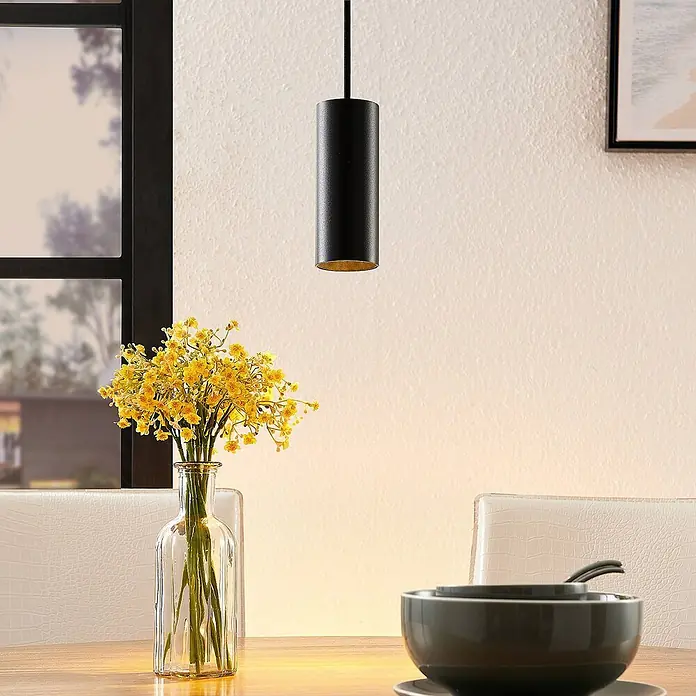 Arcchio Pendelleuchte Ejona - schwarz, Schwarz, GU10 - Schwarze zylindrische Pendelleuchte mit goldener Innenseite, die über einem Esstisch hängt und warmes Licht spendet.