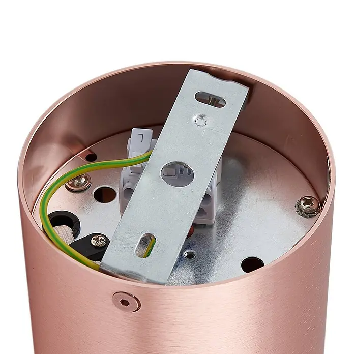 Arcchio Deckenstrahler Jolina - kupfer, GU10 - Innenansicht einer zylinderförmigen Leuchte in Roségold mit Elektroanschlüssen, grün/gelbem Erdungskabel und Montagehalterung.