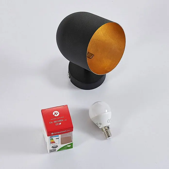 Lindby Deckenstrahler Morik - L x B x H: 19 x 10 x 12 cm, schwarz, schwarz, E14 - Schwarze zylindrische Wandleuchte mit goldener Innenseite, E14 LED-Lampe und deren roter Verpackung.