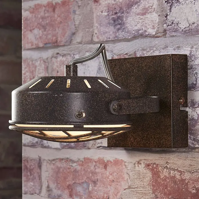 Lindby Deckenstrahler Tamin - L x B x H: 18 x 13 x 13 cm, braun / rost, braun / rost, G9 - Industrielle Wandleuchte mit dunklem, gesprenkeltem Metallfinish, flexiblem Arm und Käfigschirm an einer Ziegelwand.