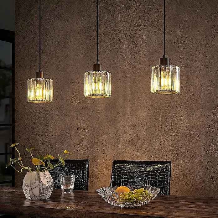 Lindby Pendelleuchte Vella - L x B x H: 83 x 13 x 12,3 cm, klar / transparent, mattSchwarz, transparent, E27 - Drei elegante Pendelleuchten mit geriffelten Glasschirmen und dunklen Fassungen, die warmes Licht über einem Esstisch spenden.
